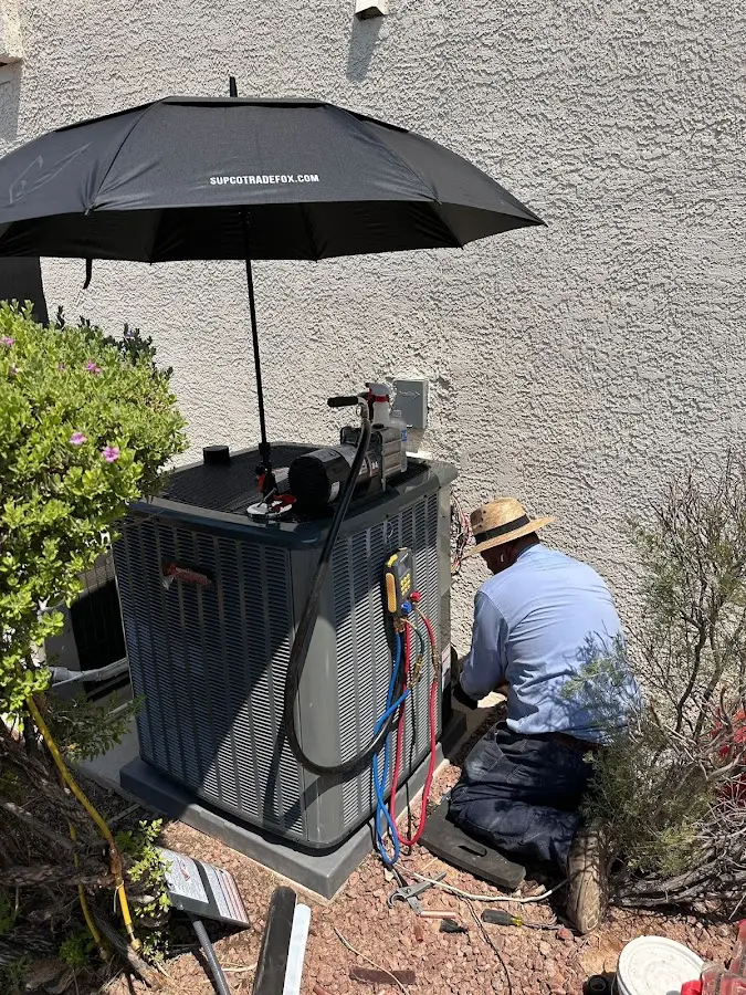 HVAC technician performing outdoor AC maintenance in Manitowoc