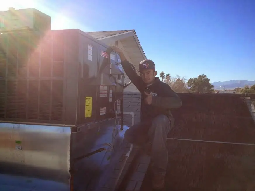 HVAC technician performing AC Tune-Up on a rooftop unit in Manitowoc